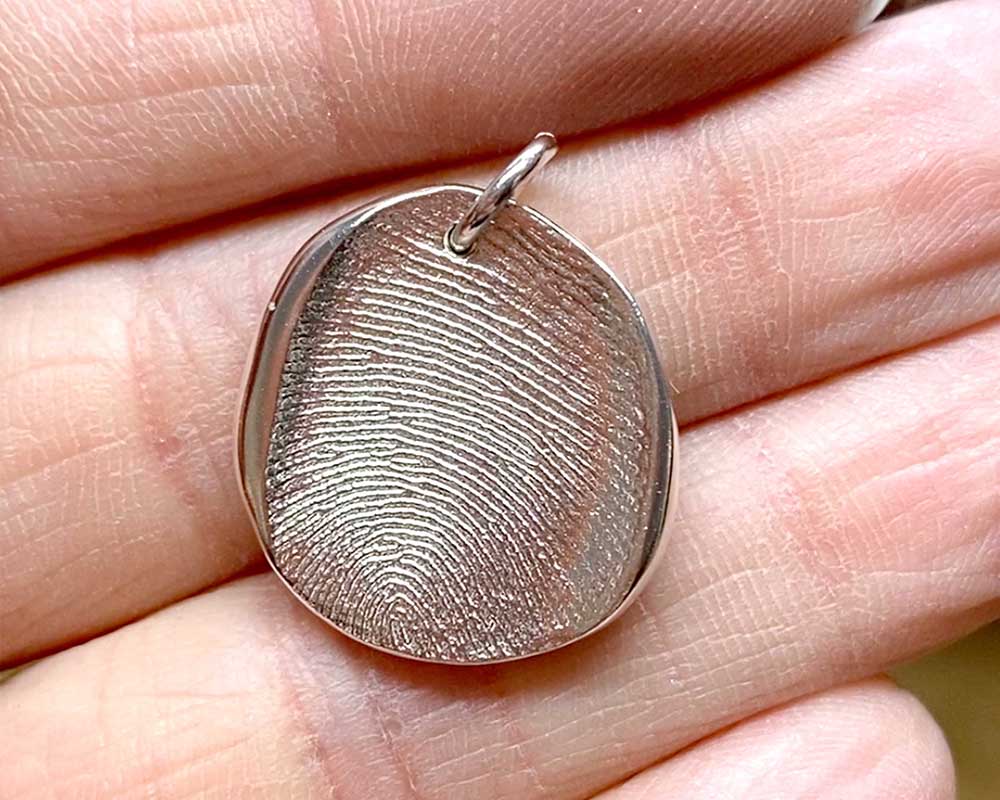 Pendentif dans la main avec empreinte digitale